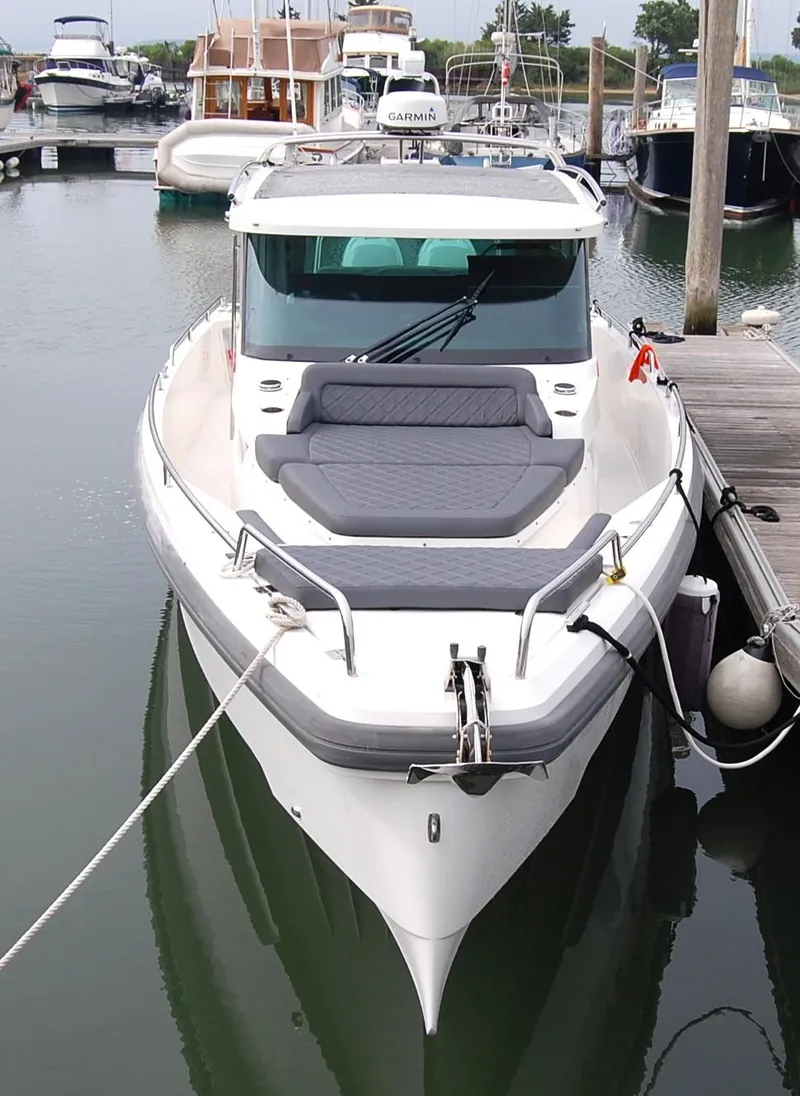 Slide: The Image of 2019 Axopar 37 SC boat docked in a marina, featuring sleek design and comfortable seating. - 3