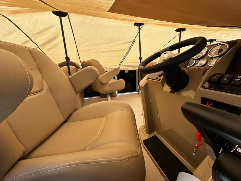 Slide: The Image of Interior of 2025 Sylvan Mirage 8520 LZ boat with beige seating and steering console. - 4