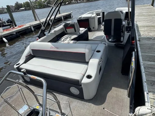 Slide: The Image of 2023 Barletta CORSA 23 UA pontoon boat with spacious seating, docked by the water. - 8