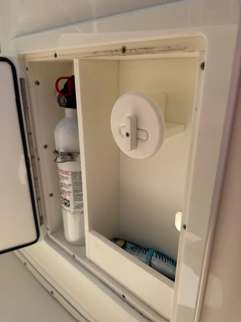 Slide: The Image of 2018 Key West Billistic 281 Center Console storage compartment with fire extinguisher and supplies. - 16