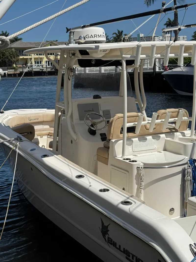 Slide: The Image of 2018 Key West Billistic 281 Center Console boat docked, featuring Garmin equipment and spacious seating. - 2