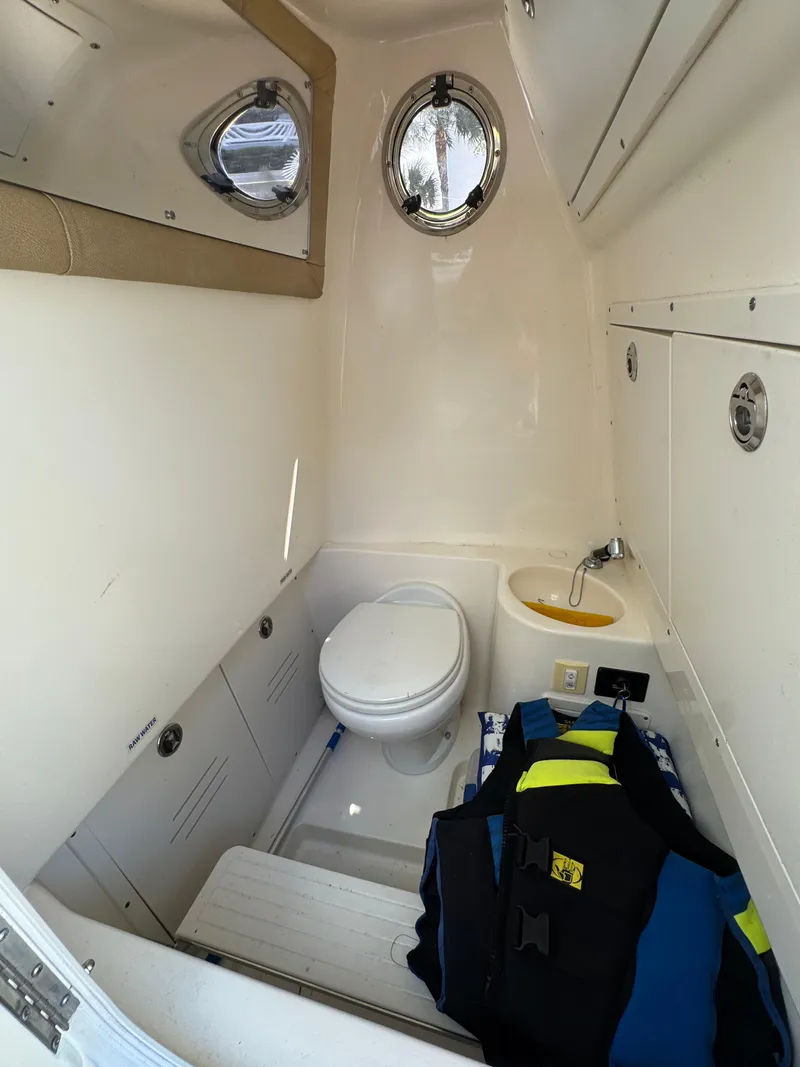 Slide: The Image of 2018 Key West Billistic 281 Center Console boat interior with toilet and life jacket. - 21