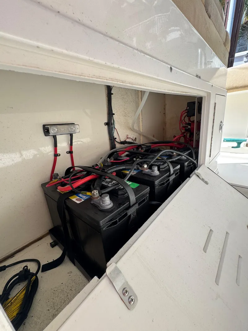 Slide: The Image of 2018 Key West Billistic 281 Center Console battery compartment with multiple batteries and wiring. - 22