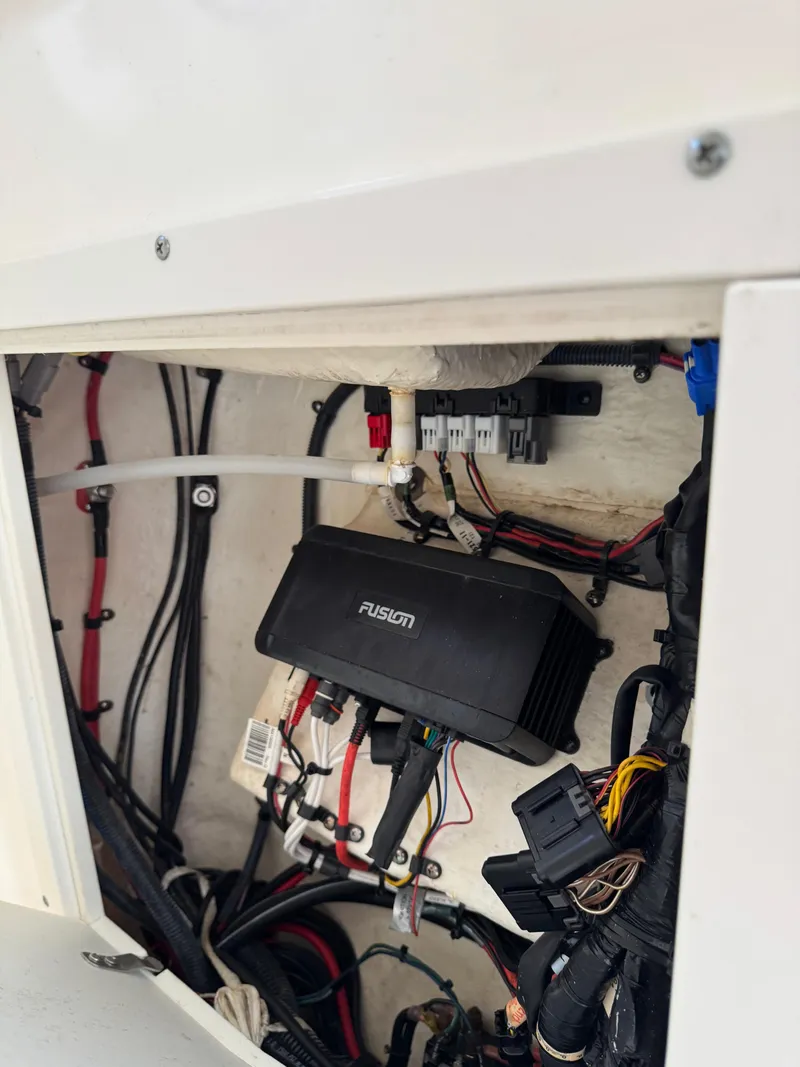 Slide: The Image of 2018 Key West Billistic 281 Center Console wiring compartment with Fusion audio system components. - 24