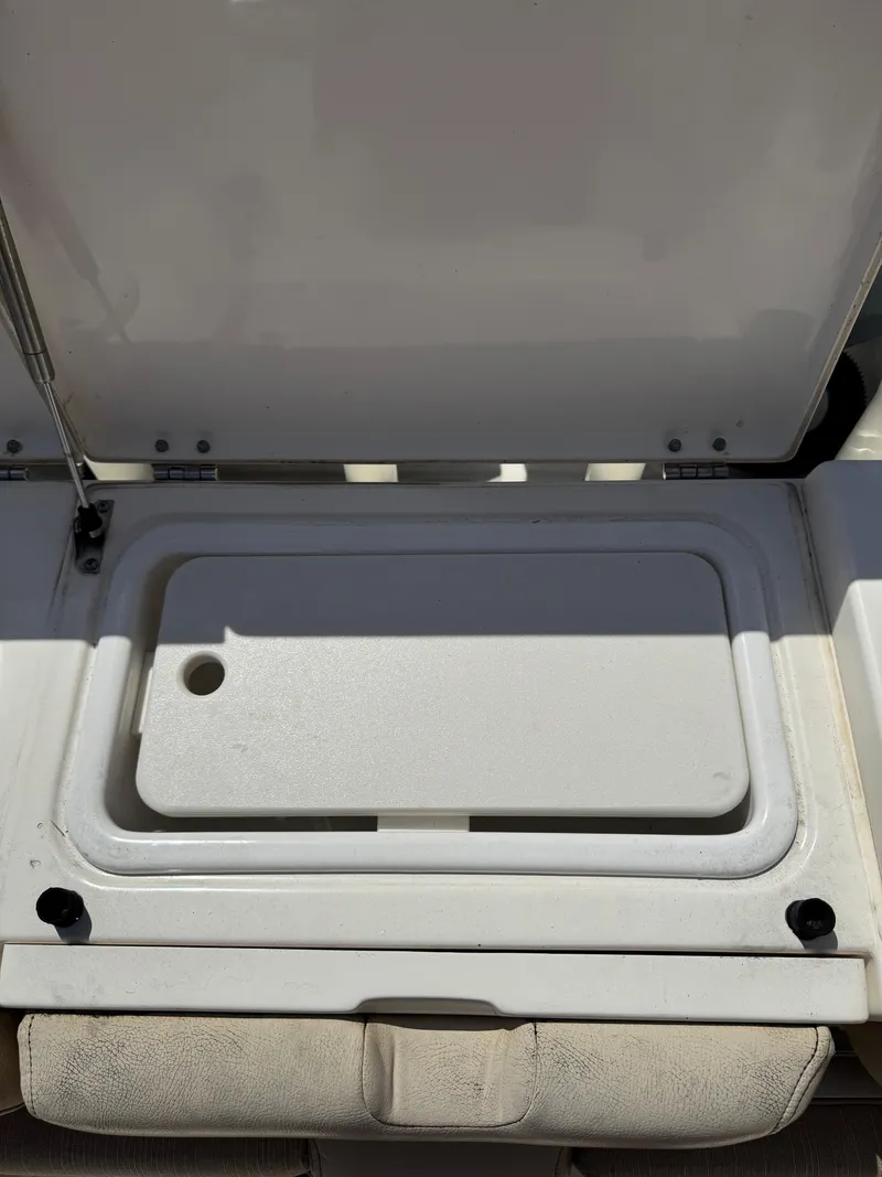 Slide: The Image of 2018 Key West Billistic 281 Center Console storage compartment with open lid. - 35