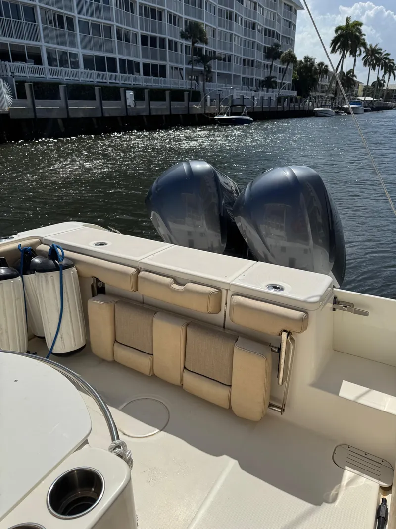 Slide: The Image of 2018 Key West Billistic 281 Center Console boat with dual engines, docked near waterfront buildings. - 36
