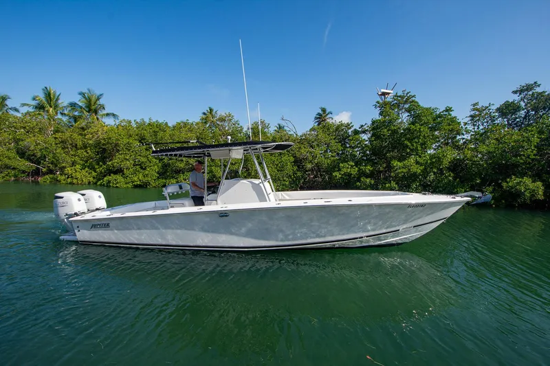 Slide: The Image of 1997 Jupiter 31 Open boat cruising on a calm, green waterway with lush greenery. - 10
