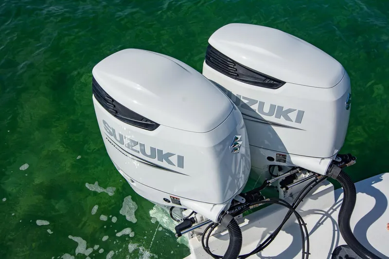 Slide: The Image of Twin Suzuki outboard motors on a 1997 Jupiter 31 Open boat in green water. - 11
