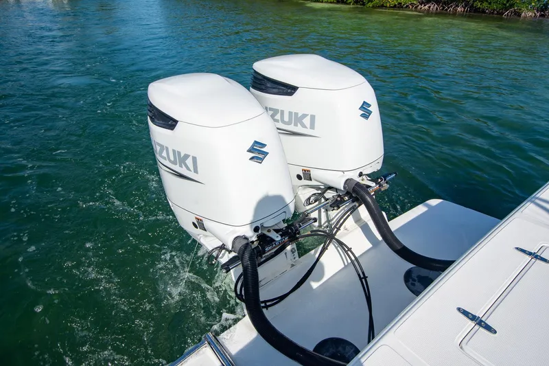 Slide: The Image of Twin Suzuki outboard motors on a 1997 Jupiter 31 Open boat in water. - 13