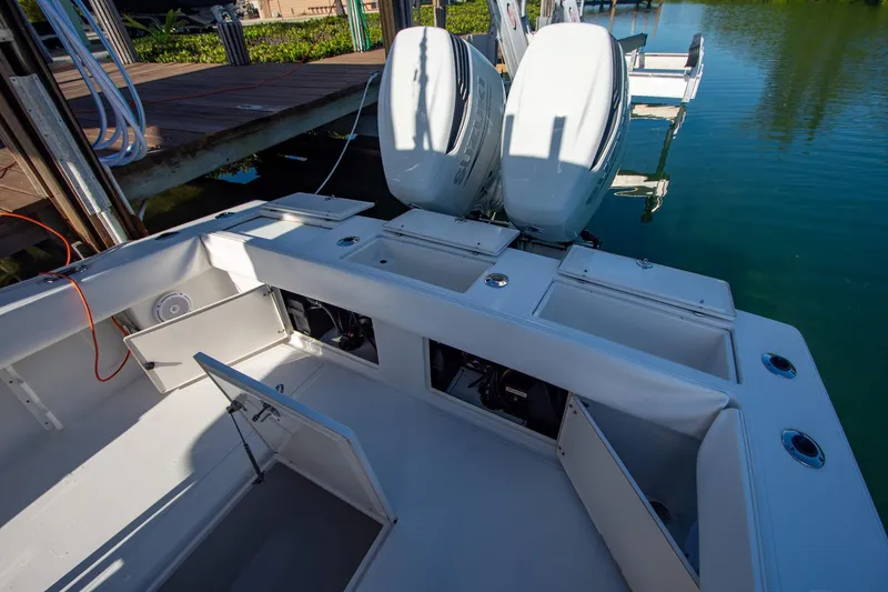 Slide: The Image of 1997 Jupiter 31 Open boat with dual outboard engines docked on calm water. - 18