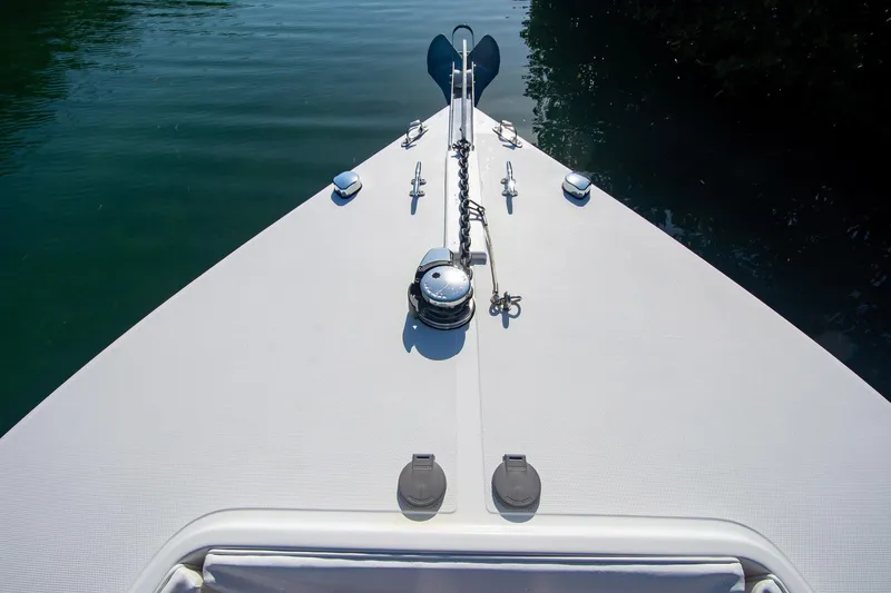 Slide: The Image of Bow of a 1997 Jupiter 31 Open boat on calm water. - 24