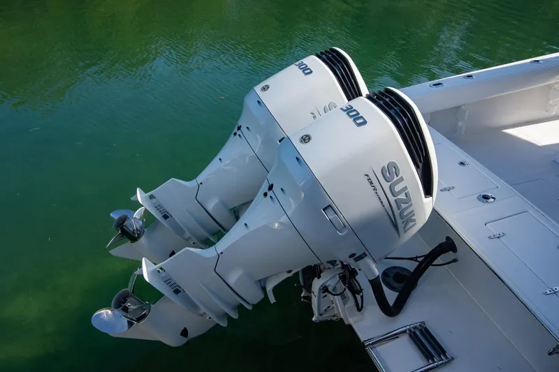 Slide: The Image of Twin Suzuki outboard motors on a 1997 Jupiter 31 Open boat in green water. - 25