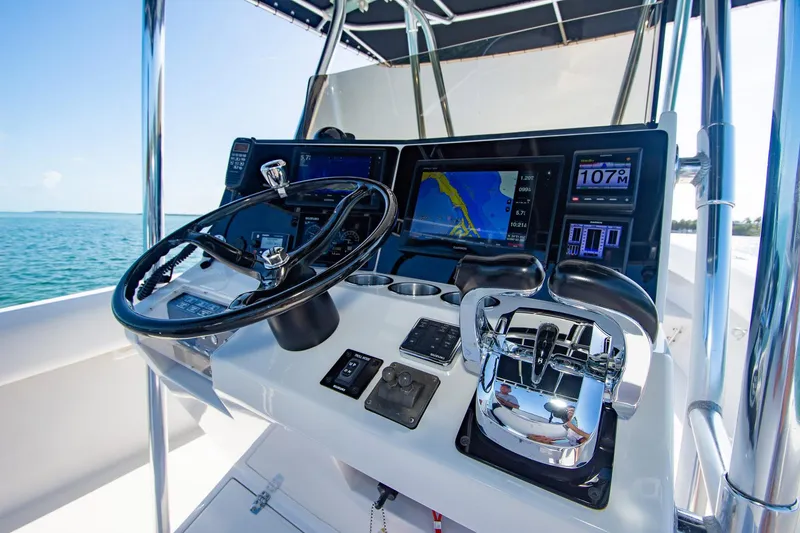 Slide: The Image of Control panel of a 1997 Jupiter 31 Open boat with navigation screens and steering wheel. - 30