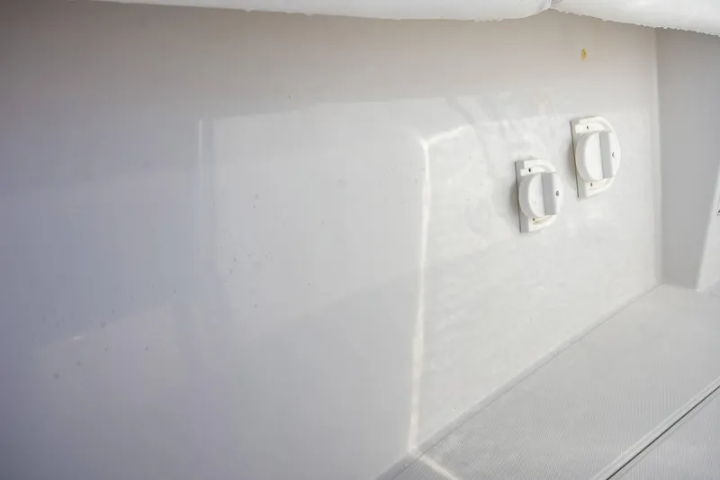 Slide: The Image of White interior of a 1997 Jupiter 31 Open boat with two circular fixtures. - 35