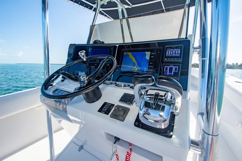 Slide: The Image of Control panel of a 1997 Jupiter 31 Open boat with navigation screens and steering wheel. - 8