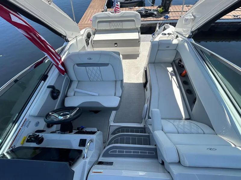 Slide: The Image of 2022 Regal 28 Express boat interior with white seating and steering wheel. - 16