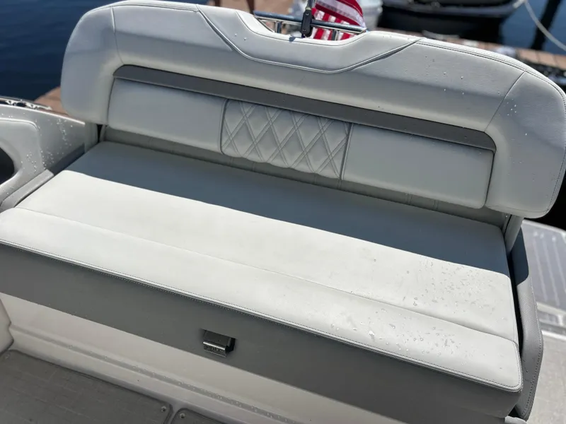 Slide: The Image of 2022 Regal 28 Express boat seat with diamond-patterned upholstery, docked by the water. - 23
