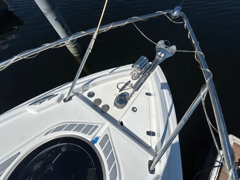 Slide: The Image of 2022 Regal 28 Express boat bow with anchor and railing, docked on calm water. - 29