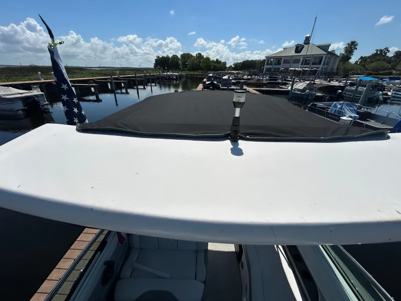 Slide: The Image of 2022 Regal 28 Express boat docked at marina under clear blue sky. - 30