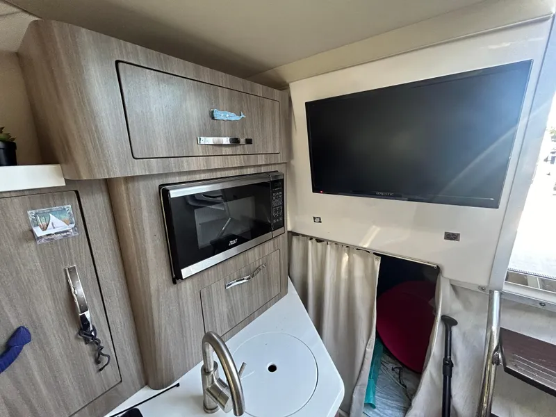 Slide: The Image of Interior of 2022 Regal 28 Express boat with TV, microwave, and sink. - 34