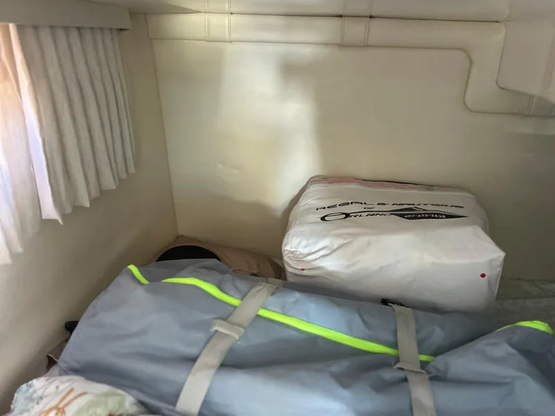 Slide: The Image of Interior cabin storage of 2022 Regal 28 Express boat with bags and gear. - 36