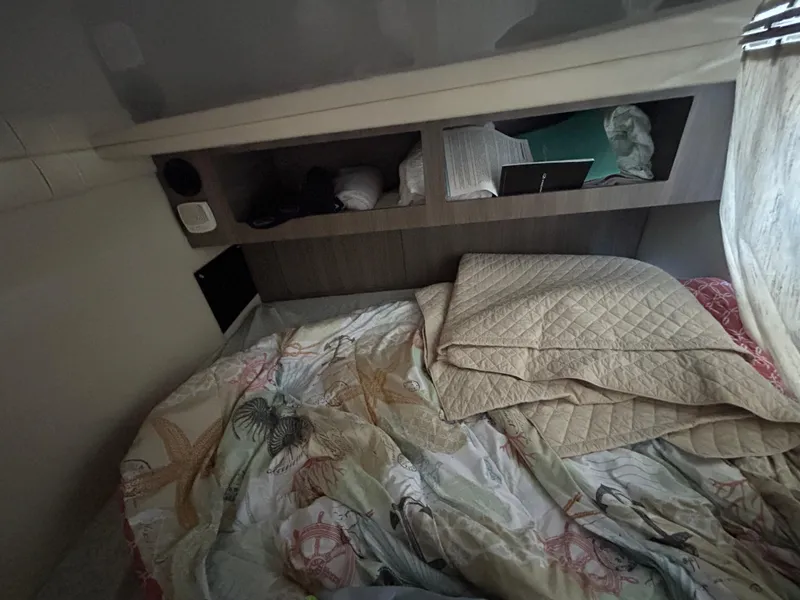 Slide: The Image of Cozy cabin interior of 2022 Regal 28 Express boat with bedding and storage shelves. - 37