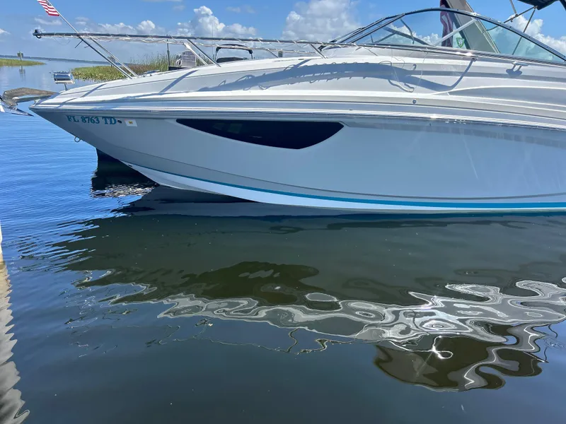Slide: The Image of 2022 Regal 28 Express boat docked on calm water under a clear blue sky. - 8