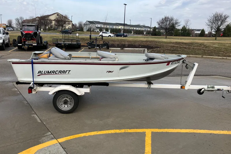Slide: The Image of 2001 Alumacraft T12V boat on trailer in parking lot. - 1