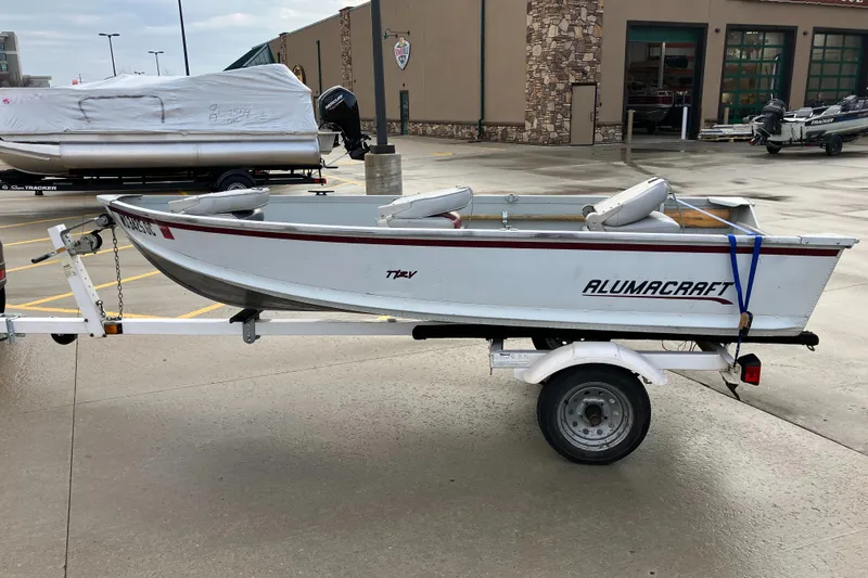Slide: The Image of 2001 Alumacraft T12V boat on trailer in parking lot. - 3