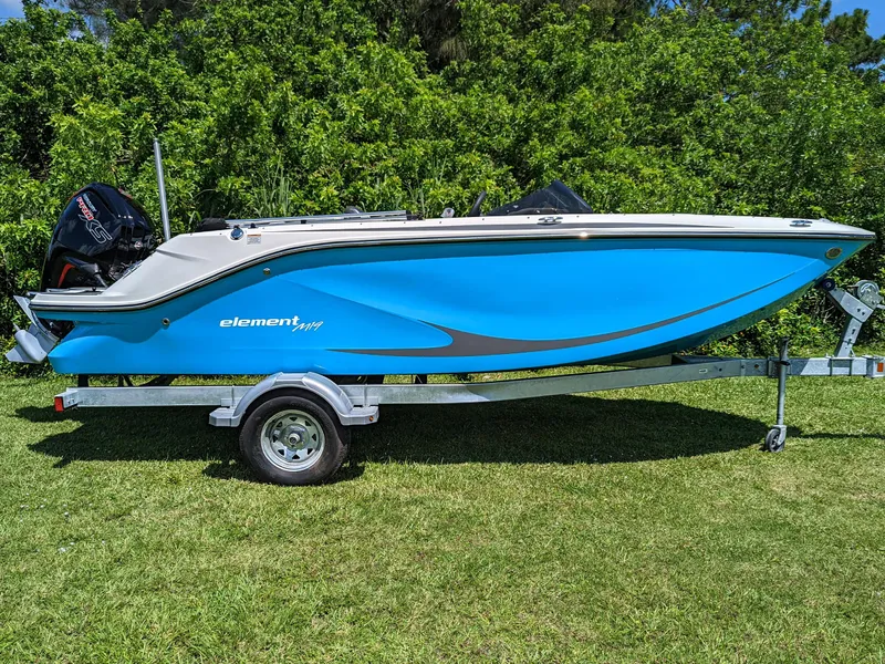 Slide: The Image of 2024 Bayliner Element M19 boat on trailer, vibrant blue hull, parked on grass. - 10
