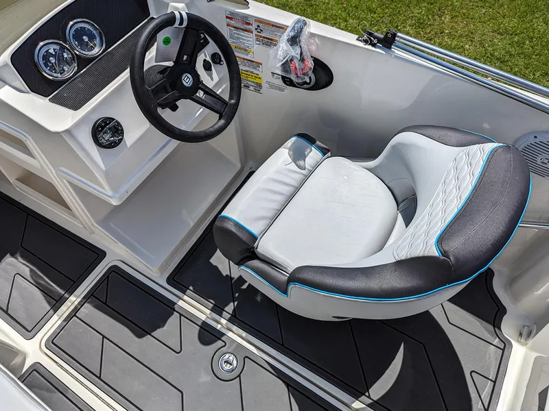 Slide: The Image of 2024 Bayliner Element M19 boat cockpit with steering wheel and cushioned seat. - 17