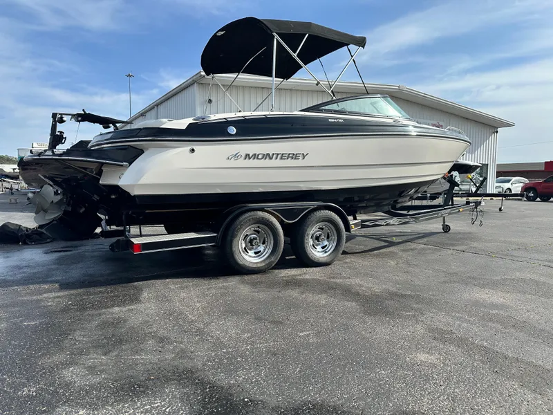 Slide: The Image of 2013 Monterey 224FXS boat on trailer, parked outdoors under clear sky. - 3