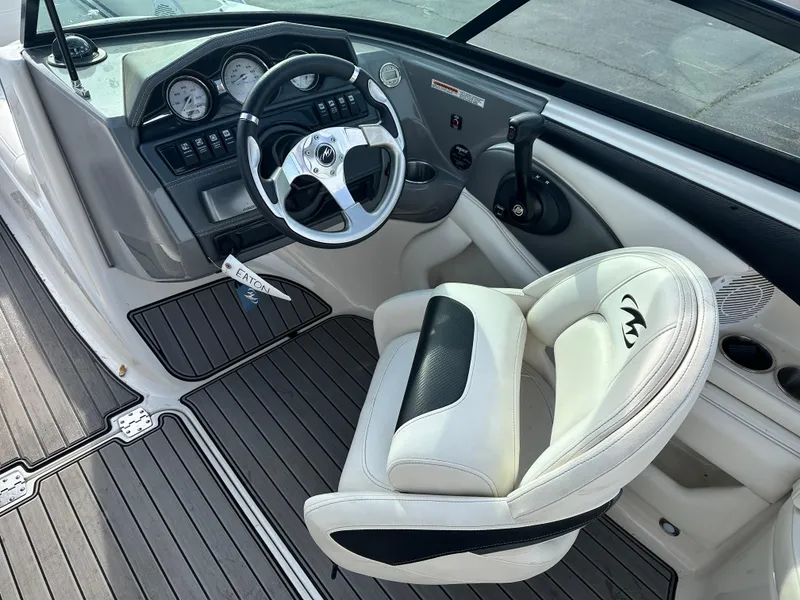 Slide: The Image of 2013 Monterey 224FXS boat cockpit with steering wheel and captain's chair. - 4