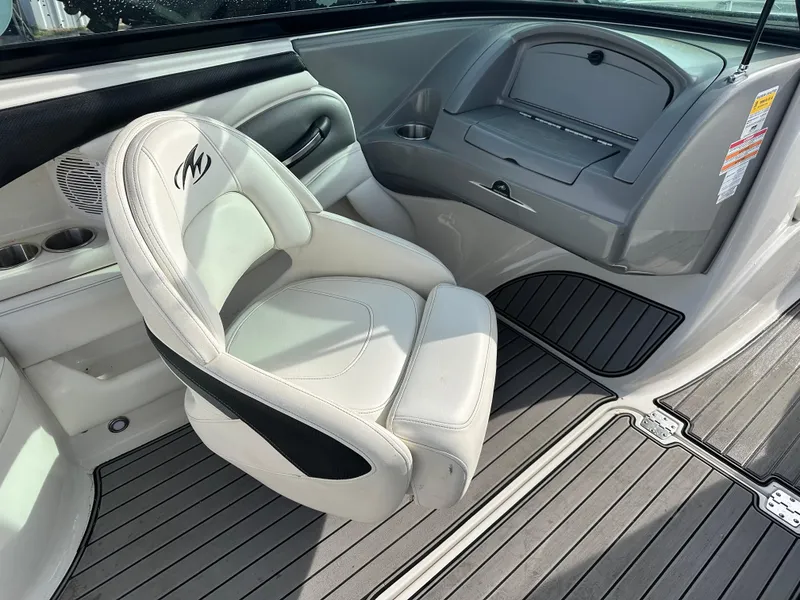 Slide: The Image of 2013 Monterey 224FXS boat interior with white seating and gray flooring. - 6