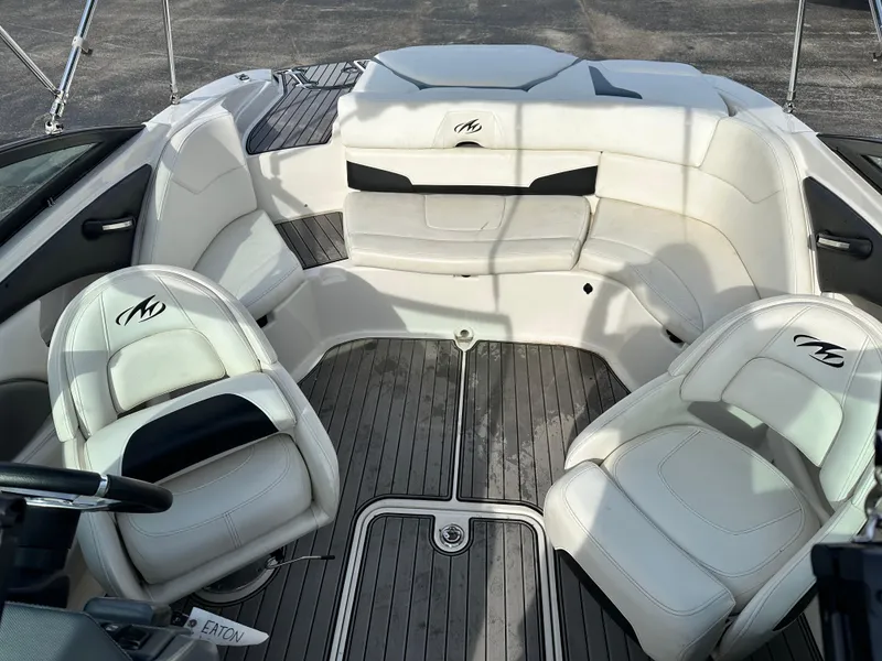 Slide: The Image of 2013 Monterey 224FXS boat interior with white seating and wood flooring. - 8