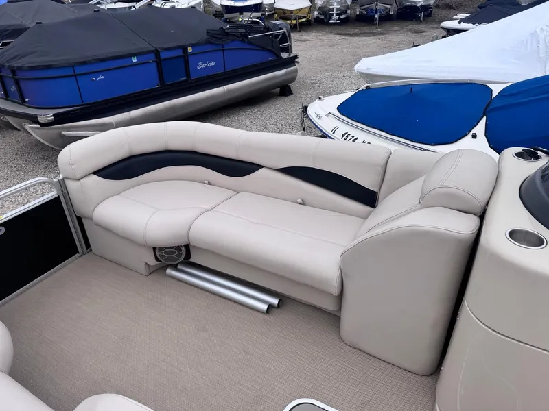 Slide: The Image of Luxurious seating on a 2014 Godfrey AP240EL3 pontoon boat, surrounded by covered boats. - 4