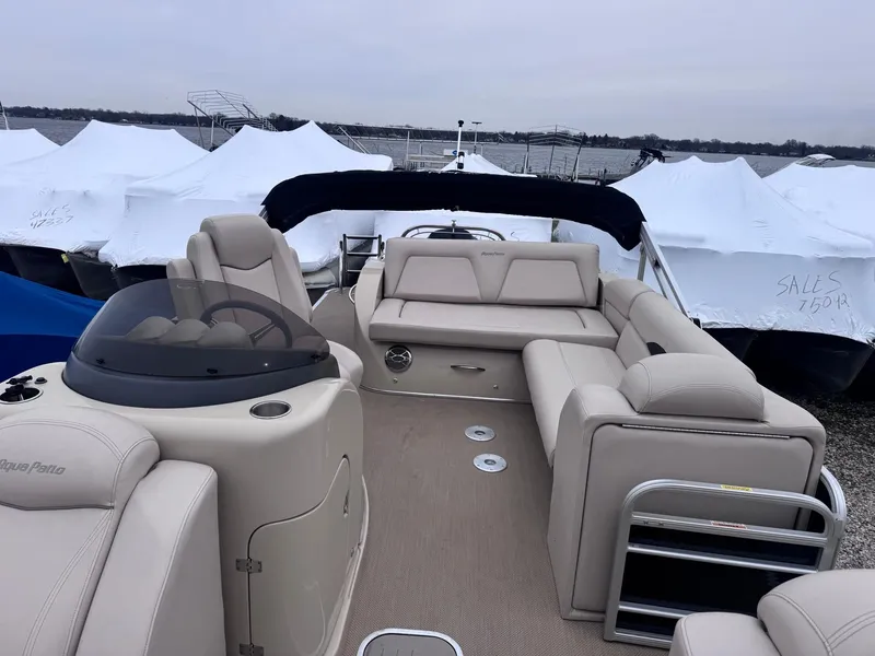 Slide: The Image of 2014 Godfrey AP240EL3 pontoon boat with beige seating, docked near covered boats. - 6