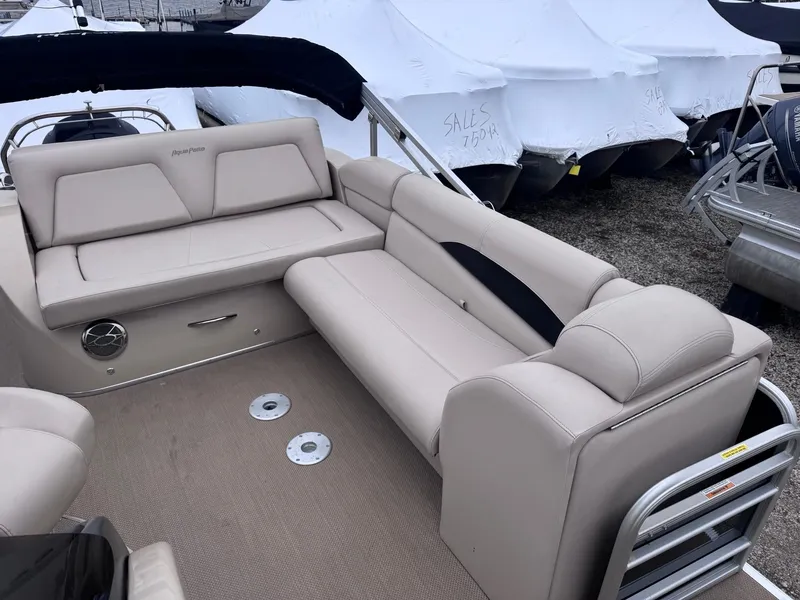 Slide: The Image of 2014 Godfrey AP240EL3 pontoon boat with beige seating, docked near covered boats. - 7