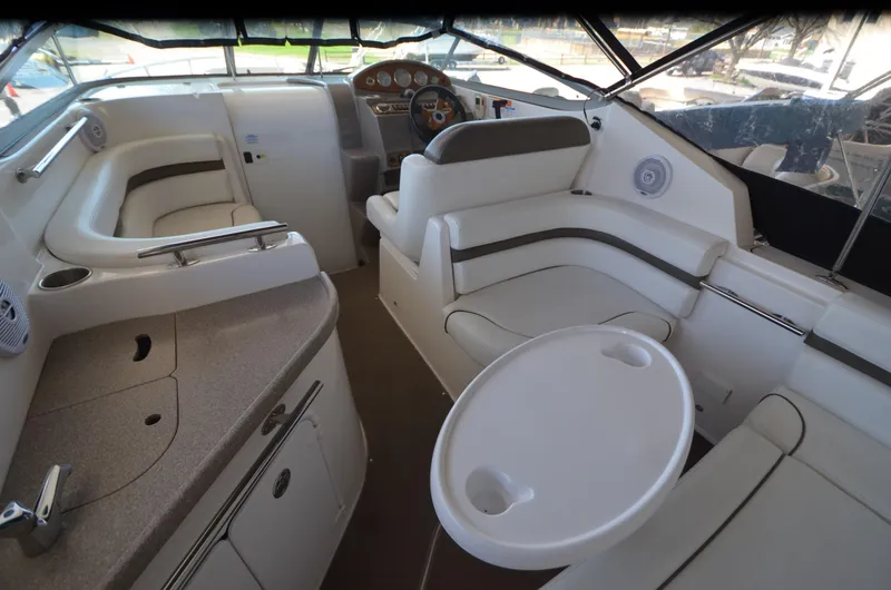 Slide: The Image of 2008 Rinker 260 EC boat interior with seating, table, and helm. - 12