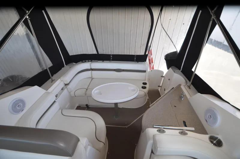 Slide: The Image of 2008 Rinker 260 EC boat interior with seating and table, enclosed by canopy. - 15