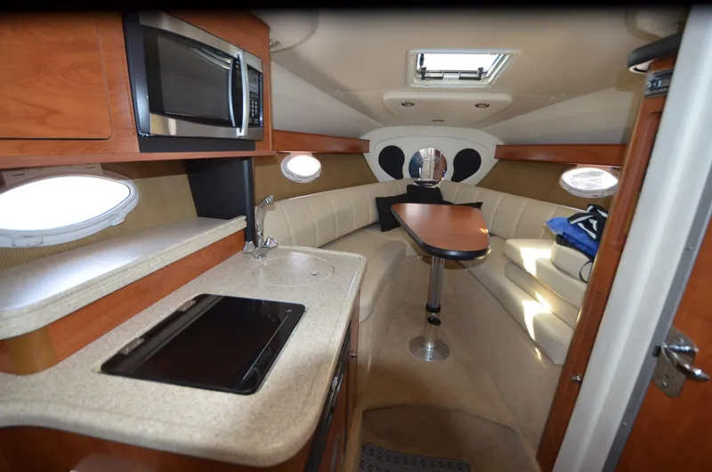 Slide: The Image of 2008 Rinker 260 EC cabin interior with kitchenette, seating, and table. - 18