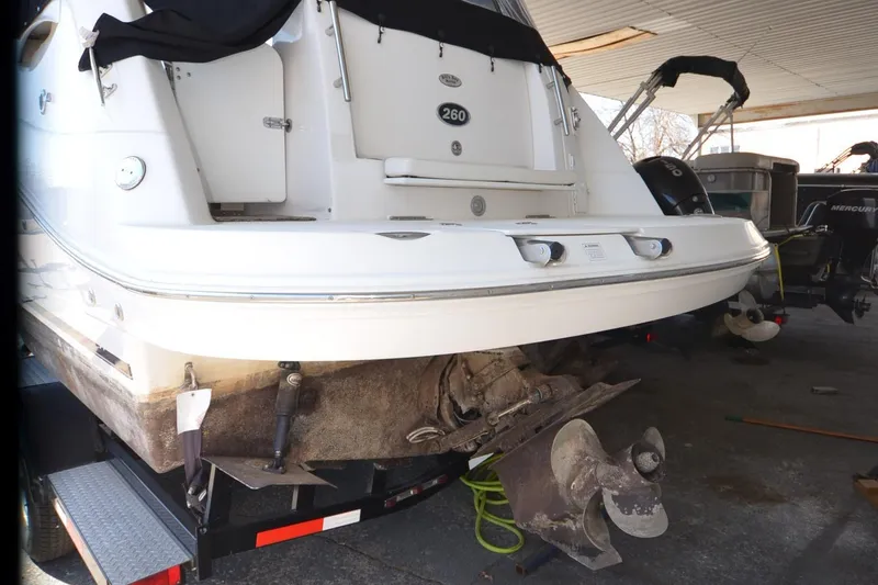 Slide: The Image of 2008 Rinker 260 EC boat on trailer, rear view showing propeller and hull details. - 20