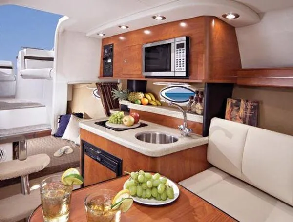 Slide: The Image of 2008 Rinker 260 EC boat interior with kitchenette, fruits, and drinks on table. - 4
