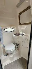 Slide: The Image of 2008 Rinker 260 EC boat bathroom with toilet, sink, and porthole window. - 9