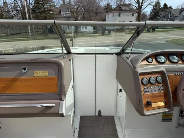 Slide: The Image of Interior view of a 1995 Cobalt 252 boat dashboard with gauges and steering wheel. - 13