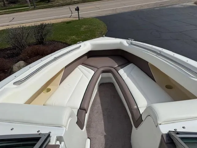 Slide: The Image of 1995 Cobalt 252 boat interior with white and brown seating, parked on a driveway. - 15