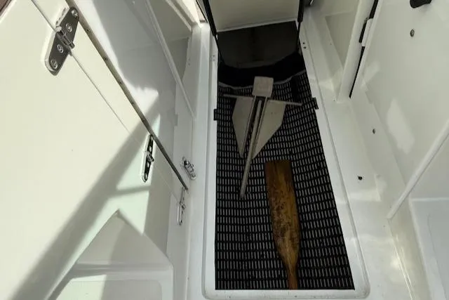 Slide: The Image of Interior of a 1995 Cobalt 252 boat with anchor and paddle on floor mat. - 23