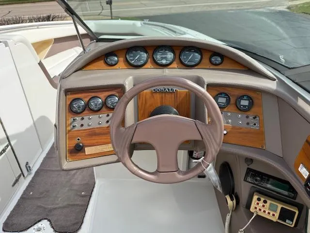 Slide: The Image of Steering wheel and dashboard of a 1995 Cobalt 252 boat with wood panel accents. - 8
