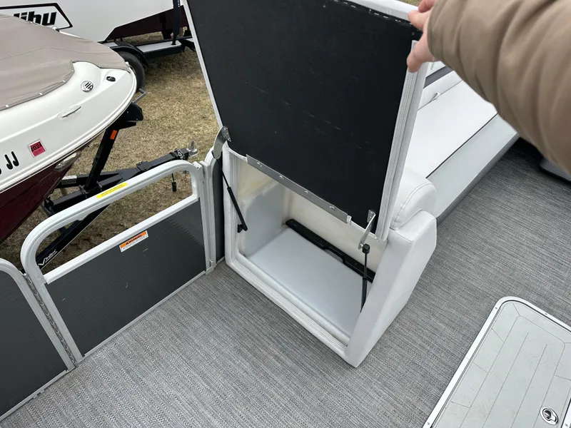 Slide: The Image of 2021 Godfrey Sweetwater 2486 SB boat with open storage compartment and gray flooring. - 28