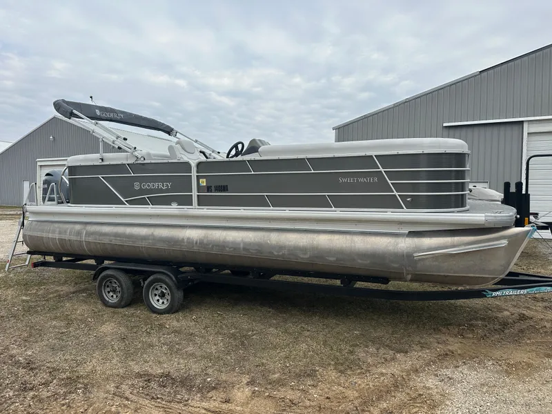 Slide: The Image of 2021 Godfrey Sweetwater 2486 SB pontoon boat on trailer, parked outdoors. - 4